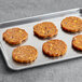 A tray of Dr. Praeger's Black Bean Quinoa Veggie Burger patties on a baking sheet.