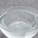 A clear glass bowl of clear liquid with bubbles in it.