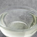 A clear glass bowl filled with Malt Products RiceRite 60DE Rice Syrup over a bowl of water with bubbles.