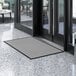 A grey Lavex waffle indoor entrance mat on a marble floor.