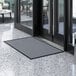 A grey rectangular Lavex Needle Rib entrance mat on a floor.