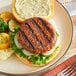 A plate of food with a Dr. Praeger's Plant-Based Vegan Perfect Burger and vegetables.