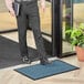 A man standing on a blue Lavex parquet entrance mat.