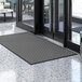 A black Lavex parquet entrance mat with a gray pattern on it.