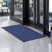 A blue Lavex waffle entrance mat placed in front of a door.