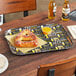 A Cambro rectangular tray with beer and a pretzel on it.