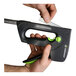 A hand holding a black and green Surebonder TriggerFire staple gun.