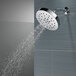 A Delta Lumicoat Chrome shower head with water running out of it.