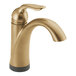 A Delta champagne bronze deck-mount faucet with a curved handle.