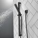 A Delta handheld shower head on a slide bar.