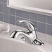 A chrome Delta deck-mount lavatory faucet with a silver handle on a white sink.
