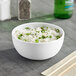 An American Metalcraft white melamine bowl filled with rice and green onions.