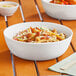 A white World Centric ZeroWare reusable bowl filled with pasta and sauce on a table.