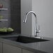 A Delta Essa kitchen faucet with an arctic stainless finish on a counter.