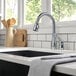 A Delta Leland kitchen faucet with a lever handle and pull-down spray wand over a sink on a white counter.