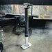 A black and silver Trailer Valet tongue jack on a trailer with a swivel wheel.