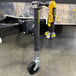 A yellow and black Trailer Valet JX side-mount drill jack tool attached to a trailer.