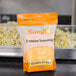 A bag of Sunglo Buttery Popcorn Salt seasoning in front of popcorn.