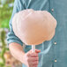 A man holding a large cotton candy made with Great Western orange cotton candy sugar.