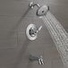 A Delta Woodhurst bath and shower faucet in chrome with a shower head.