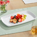 An American Metalcraft white melamine rectangle platter with fruit and cheese on it.