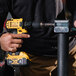 A person using a yellow and black Trailer Valet JX tongue jack with a cordless drill.