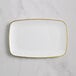 A white rectangular plastic plate with gold trim.