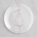 A clear Visions plastic coupe plate with a silver ring on it.