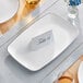 A white rectangular plastic Visions platter with a silver band on it.