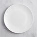 A Visions white plastic coupe plate on a marble surface.