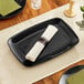A black rectangular plastic Visions platter with a green napkin on it.