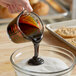 CaneRite Premium Molasses being poured into a bowl of sugar.