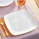 A white square Visions plastic plate with gold trim.