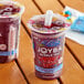 Two plastic cups of Joyba blueberry pomegranate black bubble tea with straws.