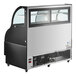 An Avantco black curved refrigerated air curtain merchandiser with a glass door.