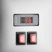 A close-up of a digital display with red buttons and a red switch.