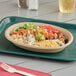 A Tellus Products natural bagasse bowl filled with food on a table.