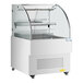 An Avantco white horizontal air curtain merchandiser with a glass door and shelf.