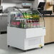An Avantco white horizontal air curtain beverage cooler with bottles in it.