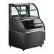 An Avantco black curved dual service refrigerated air curtain merchandiser with glass doors on a counter.