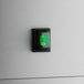 A white square bakery display case with a green light on the button.
