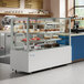 An Avantco refrigerated bakery display case with cakes on a counter.