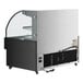 An Avantco black horizontal air curtain merchandiser with LED lighting on a counter in a bakery display.