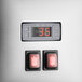 A close-up of a digital display with red buttons and a red switch.