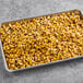 A baking pan filled with Sevillo Fine Foods fire grilled corn kernels.