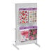A white steel pegboard countertop display stand with various cards and paper on it.