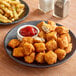 A plate of Gardein Plant-Based Vegan Breaded Chick'n Nuggets with ketchup and french fries.