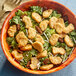 A bowl of salad with Gardein Plant-Based Crispy Chick'n Pieces on a table.