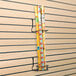 A white 5 1/2" steel vertical display rack for slatwalls.