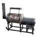 A J&R Manufacturing Jefe 250 offset smoker, a large metal barrel with a pipe and a wooden handle.